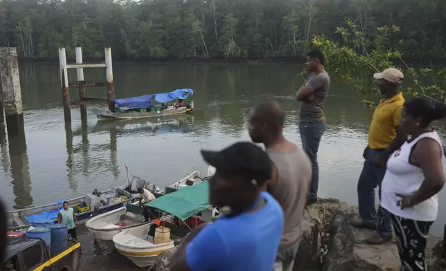 Residents gather on the dock in Puerto Kimba, Panama, Saturday, April 5, 2025. (AP Photo/Matias Delacroix)