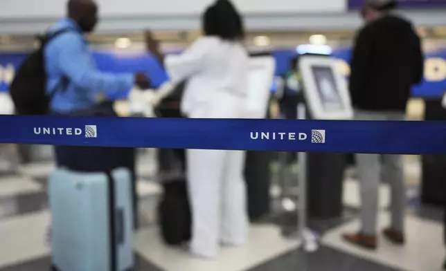 Travelers print out their boarding passes at kiosks inside of O'Hare International Airport in Chicago, Friday, May 23, 2025. (AP Photo/Nam Y. Huh)