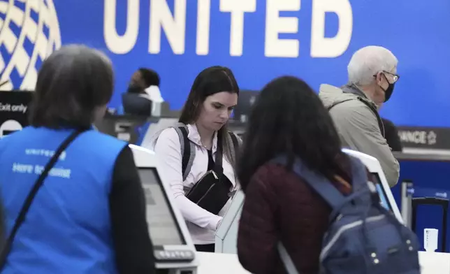 Travelers print their boarding passes at kiosks inside of O'Hare International Airport in Chicago, Friday, May 23, 2025. (AP Photo/Nam Y. Huh)