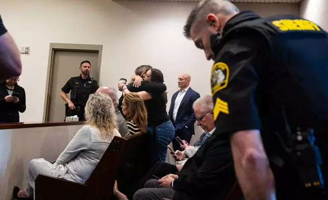 Supporters of former Grand Rapids Police officer Christopher Schurr hug after Judge Christina Mims declared a mistrial at the Kent County Courthouse in Grand Rapids, Mich., Thursday, May 8, 2025. (Joel Bissell/MLive.com/Kalamazoo Gazette via AP)