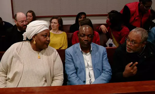 Patrick Lyoya's parents Dorcas, left, and Peter talk with translator Israel Siku, right, during a break in the sixth day of trial for former Grand Rapids Police officer Christopher Schurr, who is charged with second-degree murder in the fatal shooting of Patrick Lyoya, a Congolese immigrant, at the Kent County Courthouse in Grand Rapids, Mich., Monday, May 5, 2025. (Joel Bissell/MLive.com/Kalamazoo Gazette via AP)