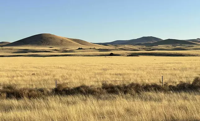 The grasslands and rolling volcanic hills where an energy developer has proposed erecting more than 100 wind turbines, a project drawing opposition among residents in nearby Springerville, Ariz., is pictured Tuesday, April 22, 2025. (AP Photo/Susan Montoya Bryan)