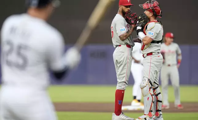 Philadelphia Phillies catcher J.T. Realmuto, right, talks to pitcher Cristopher Sánchez, center, before facing Tampa Bay Rays' Curtis Mead during the first inning of a baseball game Wednesday, May 7, 2025, in Tampa, Fla. (AP Photo/Chris O'Meara)