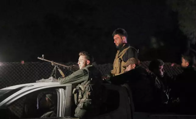 Syrian security forces stand on their vehicle after reaching a deal with Druze gunmen to deploy around Jaramana, a Damascus suburb that saw fighting earlier this week, in Damascus, Syria, early Friday, May 2, 2025. (AP Photo/Omar Sanadiki)