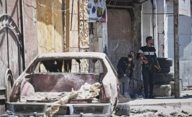 Druze gunmen stand guard near a checkpoint, a day after clashes between members of the minority Druze sect and pro-government fighters left at least four people dead in the southern suburb of Jaramana, Damascus, Syria, Tuesday, April 29, 2025. (AP Photo/Omar Sanadiki)