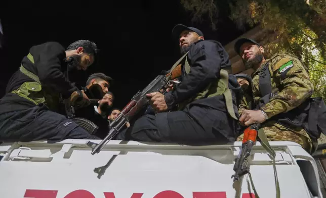 Syria's security forces stand on their vehicle, after reaching a deal with Druze gunmen to deploy around Jaramana, a Damascus suburb that saw fighting earlier this week, in Damascus, Syria, early Friday, May 2, 2025. (AP Photo/Omar Sanadiki)