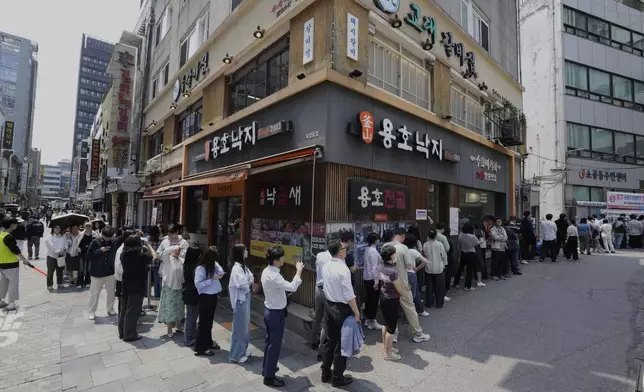 People wait in line to cast their early votes for the June 3 presidential election near a polling station in Seoul, South Korea, Thursday, May 29, 2025. (AP Photo/Ahn Young-joon)