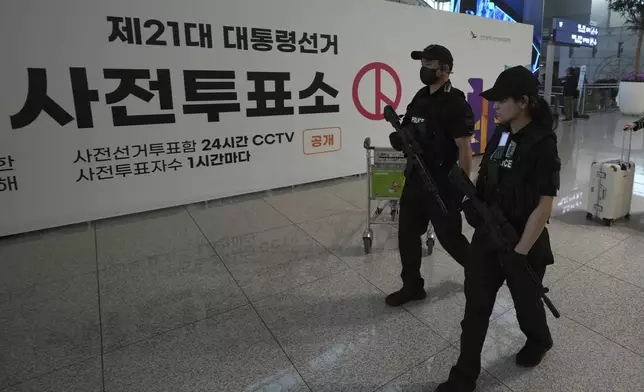 Police officers patrol near a polling station for the early votes of the June 3 presidential election at the departure hall of Incheon International Airport in Incheon, South Korea, Thursday, May 29, 2025. (AP Photo/Lee Jin-man)