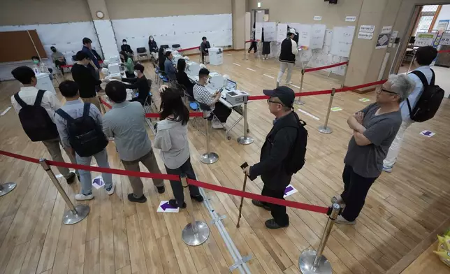 People wait in line to cast their early votes for the June 3 presidential election at a polling station in Seoul, South Korea, Thursday, May 29, 2025. (AP Photo/Ahn Young-joon)