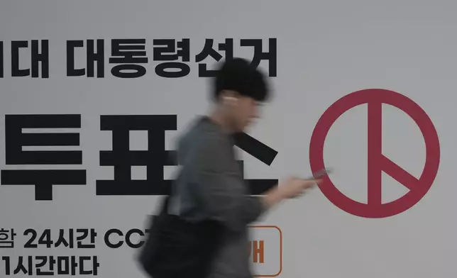 A man walks past near a polling station for the early votes of the June 3 presidential election at the departure hall of Incheon International Airport in Incheon, South Korea, Thursday, May 29, 2025. (AP Photo/Lee Jin-man)