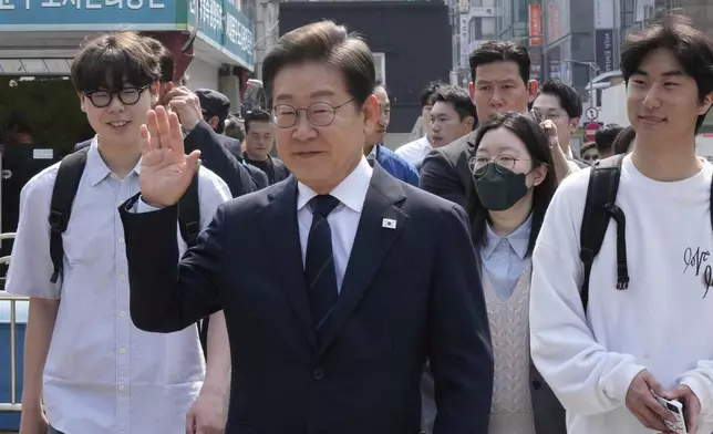South Korean Democratic Party's presidential candidate Lee Jae-myung, center, waves as he leaves after casting his early vote for the June 3 presidential election near a polling station in Seoul, South Korea, Thursday, May 29, 2025. (AP Photo/Ahn Young-joon)