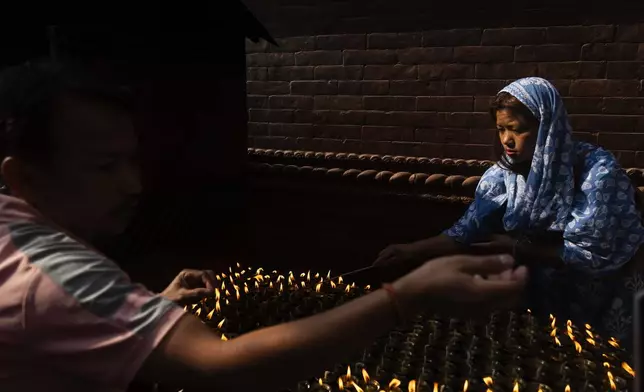 Nepalese devotees light butter lamps during Buddha Jayanti, also known as Buddha Purnima festival, to celebrate Buddha's birthday, in Boudhanath Stupa, Kathmandu, Nepal, Monday, May 12, 2025. (AP Photo/Niranjan Shrestha)