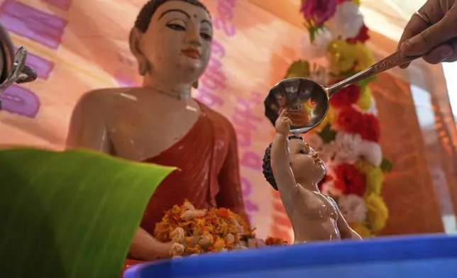 A devotee offers milk while praying in a temple on the occasion of Buddha Purnima festival in Kolkata, India, Monday, May 12, 2025. (AP Photo/Bikas Das)