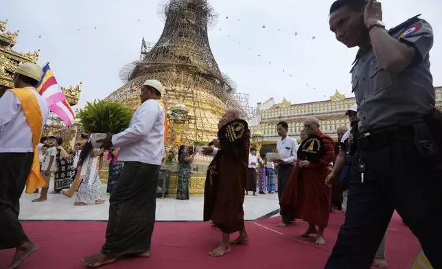 Buddhist monks and devotees walk during a religious ceremony to mark the Full Moon day of "Kasone," known as Buddha's Birthday, at Botataung pagoda Sunday, May 11, 2025, in Yangon, Myanmar. (AP Photo/Thein Zaw)