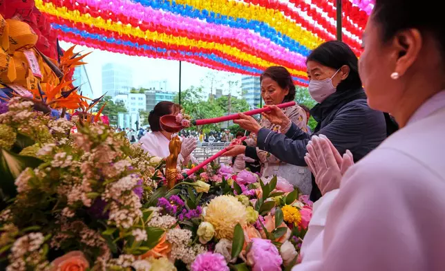 Buddhists pour water on a statue of Buddha to celebrate Buddha's birthday at the Jogye temple in Seoul, South Korea, Monday, May 5, 2025. (AP Photo/Lee Jin-man)