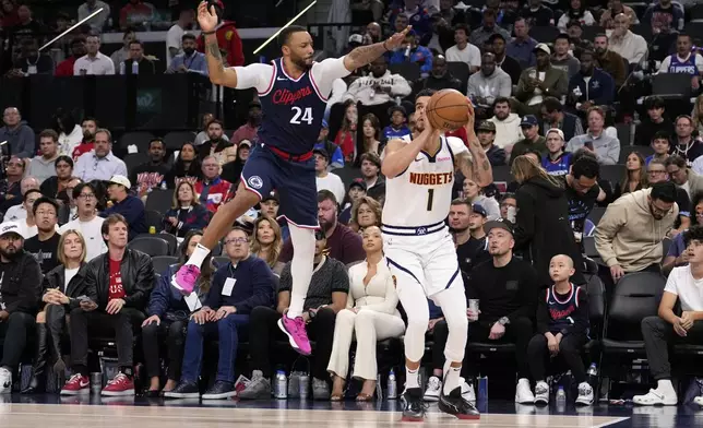 Denver Nuggets forward Michael Porter Jr., right, tries to shoot as Los Angeles Clippers guard Norman Powell defends during the second half in Game 6 of an NBA basketball first-round playoff series Thursday, May 1, 2025, in Inglewood, Calif. (AP Photo/Mark J. Terrill)