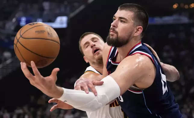 Denver Nuggets center Nikola Jokic, left, and Los Angeles Clippers center Ivica Zubac reach for a rebound during the first half in Game 6 of an NBA basketball first-round playoff series Thursday, May 1, 2025, in Inglewood, Calif. (AP Photo/Mark J. Terrill)