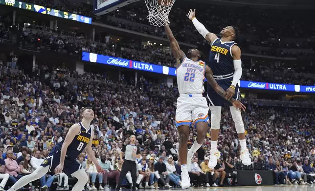 Oklahoma City Thunder guard Cason Wallace (22) drives to the basket as Denver Nuggets guards Christian Braun (0) and Russell Westbrook (4) defend in the second half of Game 4 in the Western Conference semifinals of the NBA basketball playoffs Sunday, May 11, 2025, in Denver. (AP Photo/David Zalubowski)