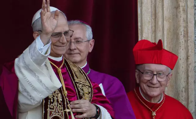 Newly elected Pope Leo XIV, left, formerly Cardinal Robert Francis Prevost, appears with, from left, Master of Ceremonies Archbishop Diego Giovanni Ravelli, and former Vatican Secretary of State Cardinal Pietro Parolin on the central loggia of St. Peter's Basilica at the Vatican shortly after his election as the 267th pontiff of the Roman Catholic Church, Thursday, May 8, 2025. (AP Photo/Domenico Stinellis)