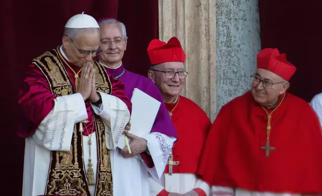 Newly elected Pope Leo XIV, left, formerly Cardinal Robert Francis Prevost, appears with, from left, Master of Ceremonies Archbishop Diego Giovanni Ravelli, Cardinal Pietro Parolin, and Cardinal Vinko Puljić on the central loggia of St. Peter's Basilica at the Vatican shortly after his election as the 267th pontiff of the Roman Catholic Church, Thursday, May 8, 2025. (AP Photo/Domenico Stinellis)