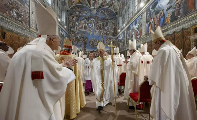 Newly elected Pope Leo XIV, center, leaves after concelebrating Mass with the College of Cardinals inside the Sistine Chapel at the Vatican the day after his election as 267th pontiff of the Roman Catholic Church, Friday, May 9, 2025. (Vatican Media via AP)