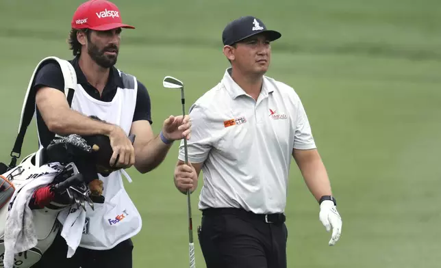 Rico Hoey, right, and his caddie approach the 8th green during the first round of the CJ Cup Byron Nelson golf tournament in McKinney, Texas, Thursday, May 1, 2025. (AP Photo/Gareth Patterson)