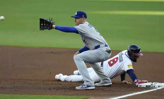 Atlanta Braves' Alex Verdugo (8) makes it back to first base against Los Angeles Dodgers first baseman Freddie Freeman (5) in the first inning of a baseball game, Sunday, May 4, 2025, in Atlanta. (AP Photo/Mike Stewart)