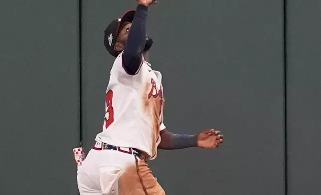Atlanta Braves outfielder Michael Harris II (23) makes the catch for the out against Los Angeles Dodgers two-way player Shohei Ohtani (17) in the fifth inning of a baseball game, Sunday, May 4, 2025, in Atlanta. (AP Photo/Mike Stewart)