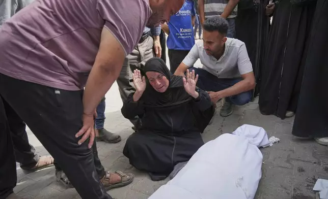 Hanan Al-Aloul mourns over the body of a relative killed earlier when an Israeli army strike hit their home, during before the funeral outside al-Shifa hospital in Gaza City, Sunday, May 18, 2025. (AP Photo/Jehad Alshrafi)