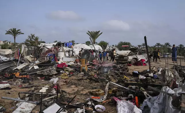 Palestinians inspect the site destroyed by Israeli airstrikes in Khan Younis, Gaza Strip, Sunday, May 18, 2025. (AP Photo/Abdel Kareem Hana)