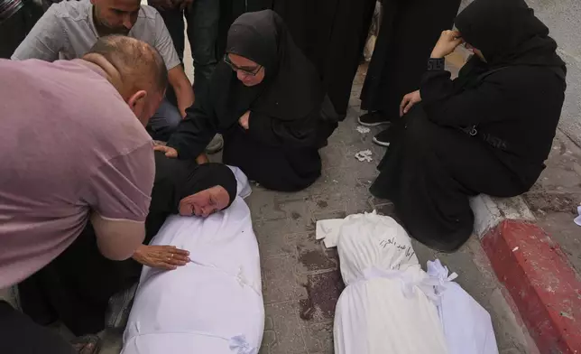 Hanan Al-Aloul mourns over the body of a relative killed earlier when an Israeli army strike hit their home, during the funeral outside al-Shifa hospital in Gaza City, Sunday, May 18, 2025. (AP Photo/Jehad Alshrafi)