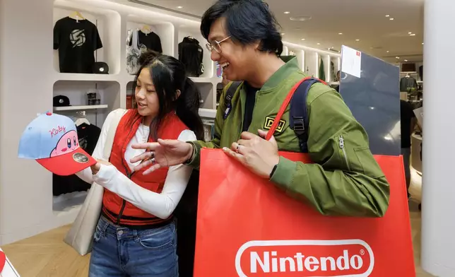 In this photo provided by Nintendo of America, fans happily explore Nintendo SAN FRANCISCO and the variety of products available, including Nintendo video game systems, games, and other character-based merchandise.