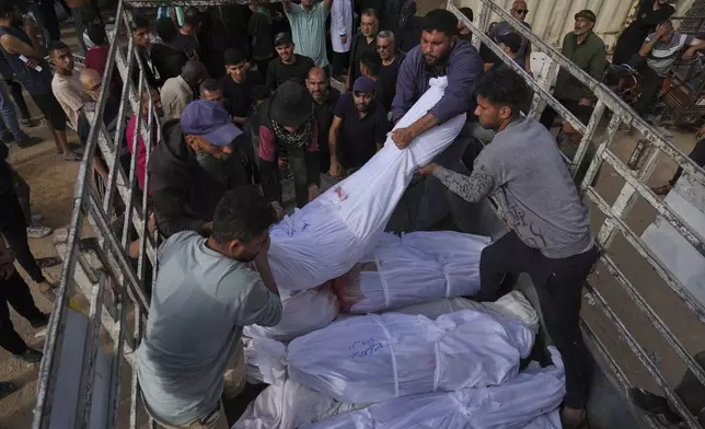 Palestinians load bodies of their relatives killed in the Israeli army airstrikes in Jabalia, northern Gaza Strip, on Wednesday, May 14, 2025. According to local hospitals, 48 people were killed in the strikes, including 22 children. (AP Photo/Jehad Alshrafi)