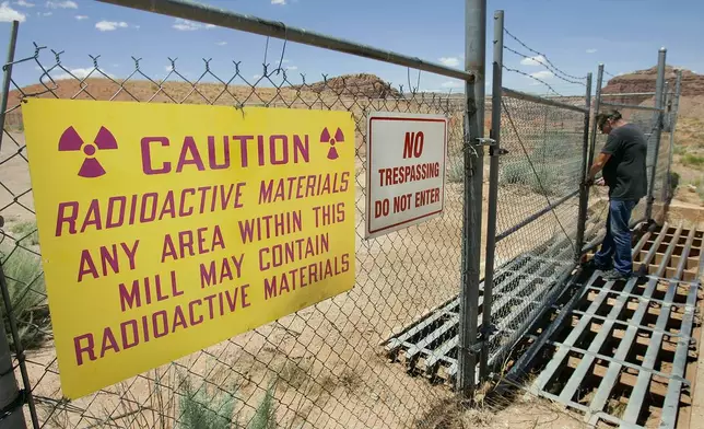 FILE - U.S. Energy Corp. resident project manager Daryl Winters locks the gate, on July 12, 2006, at the Shootaring Mill north of Ticaboo, Utah. (AP Photo/Douglas C. Pizac)