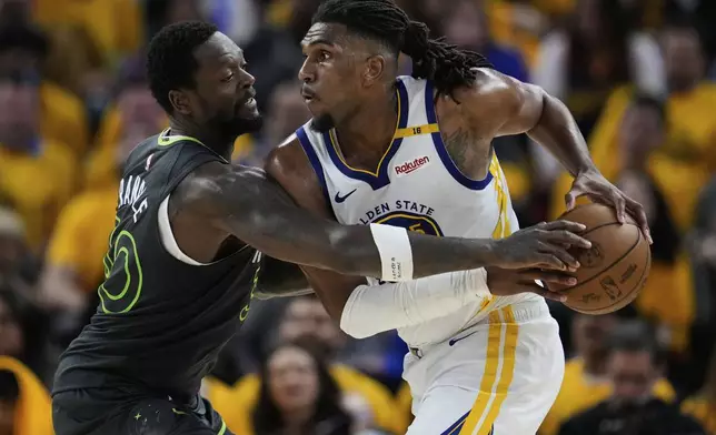 Minnesota Timberwolves forward Julius Randle, left, knocks the ball away from Golden State Warriors center Kevon Looney during the second half of Game 3 of an NBA basketball second-round playoff series Saturday, May 10, 2025, in San Francisco. (AP Photo/Godofredo A. Vásquez)