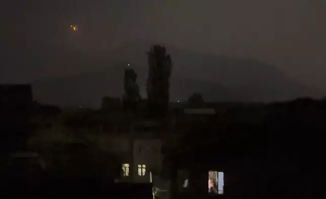 Red projectiles are seen on the horizon in Srinagar, in Indian controlled Kashmir, Saturday, May 10, 2025. (AP Photo/Mukhtar Khan)