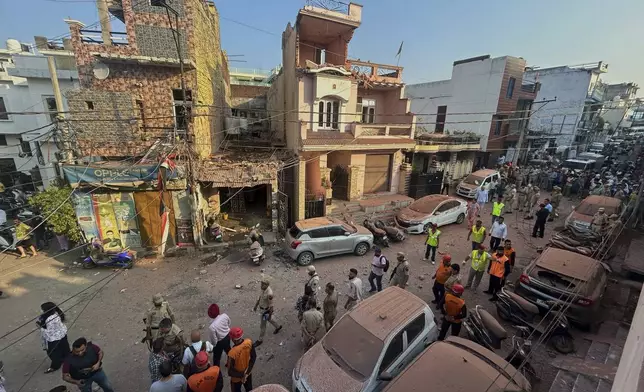 Rescuers and security personnel inspect a residential building damaged by a Pakistan's drone attack in Jammu, India, Saturday, May 10, 2025. (AP Photo/Channi Anand)