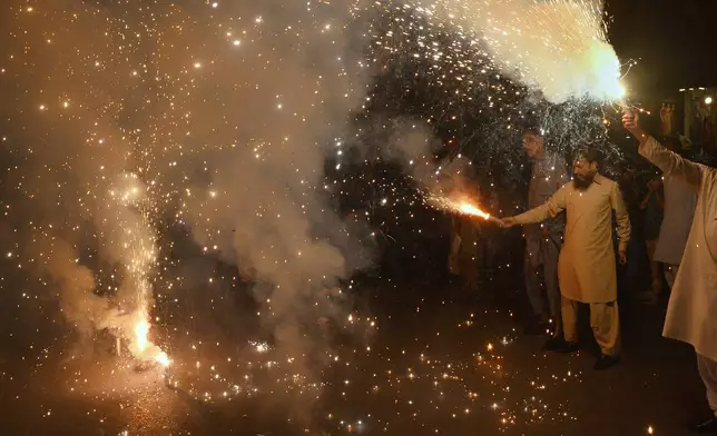 People light fireworks to celebrate Pakistan and India reaching a ceasefire deal, during a demonstration in Hyderabad, Pakistan, Saturday, May 10, 2025. (AP Photo/Pervez Masih)