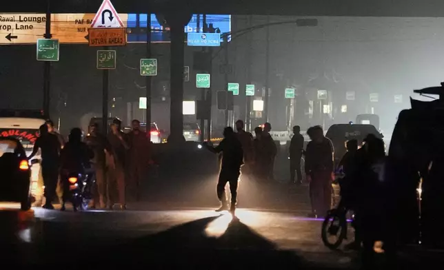Police officers remove vehicles and people from the main entry of Nur Khan airbase following Indian missile strike on airbase, in Rawalpindi, Pakistan, Saturday, May 10, 2025. (AP Photo/Anjum Naveed)