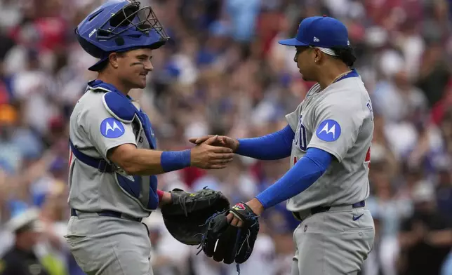 Chicago Cubs' catcher Reese McGuire, left, and pitcher Daniel Palencia, right, celebrate after winning a baseball game against the Cincinnati Reds, Sunday, May 25, 2025, in Cincinnati. (AP Photo/Carolyn Kaster)