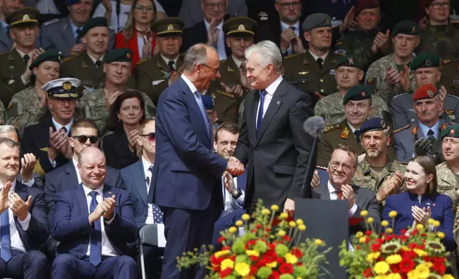 German Chancellor Friedrich Merz, left, shakes hands with Lithuania's President Gitanas Nauseda at a formal inauguration of a German brigade for NATO's eastern flank in Vilnius, Lithuania, Thursday, May 22, 2025. (AP Photo/Mindaugas Kulbis)