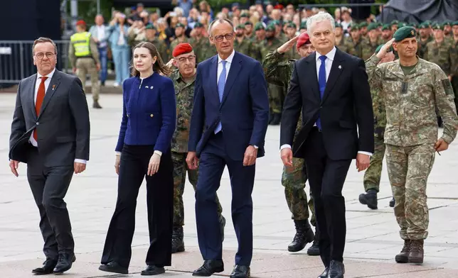 Lithuania's President Gitanas Nauseda, German Chancellor Friedrich Merz, Lithuania's defense minister Docile Sakaliene and German Defense Minister Boris Pistorius, from right, participate a formal inauguration of a German brigade for NATO's eastern flank in Vilnius, Lithuania, Thursday, May 22, 2025. (AP Photo/Mindaugas Kulbis)