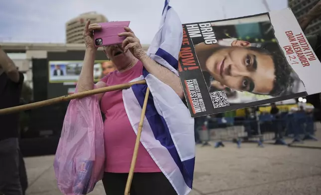 A man holds a placard of Israeli-American soldier Edan Alexander as he waits for his release from Hamas captivity in Gaza, at a plaza known as the hostages square in Tel Aviv, Monday, May 12, 2025. Alexander was abducted during the Hamas-led attack on his base on October 7, 2023. (AP Photo/Oded Balilty)