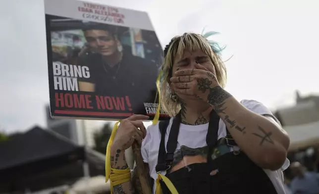 A woman cries as she gathers with others to watch a live broadcast of Israeli-American soldier Edan Alexander to be released from Hamas captivity in Gaza, at a plaza known as the hostages square in Tel Aviv, Monday, May 12, 2025. Alexander was abducted during the Hamas-led attack on his base on October 7, 2023. (AP Photo/Oded Balilty)