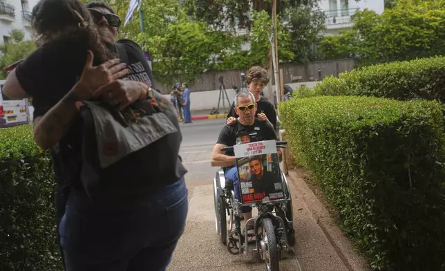 Doron, in a wheelchair, arrives along with friends and relatives to Israeli-American soldier Edan Alexander's family house ahead of his release from Hamas captivity in Gaza, in Tel Aviv, Monday, May 12, 2025. Alexander was abducted during the Hamas-led attack on his base on October 7, 2023. (AP Photo/Ohad Zwigenberg)