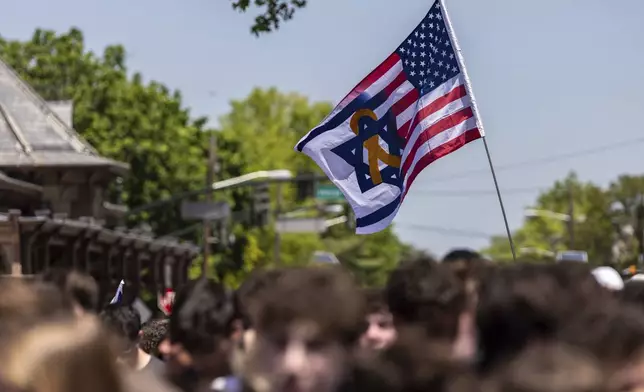 An Israeli-American flag flies in Huyler Park as people gather to celebrate the release of American hostage Edan Alexander from Hamas on Monday, May 12, 2025, in Tenafly, N.J. (AP Photo/Stefan Jeremiah)