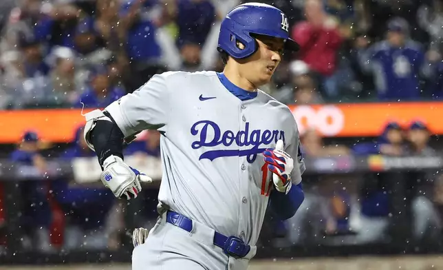 Los Angeles Dodgers' Shohei Ohtani runs to first base after hitting a single during the ninth inning of a baseball game against the New York Mets, Friday, May 23, 2025, in New York. (AP Photo/Pamela Smith)