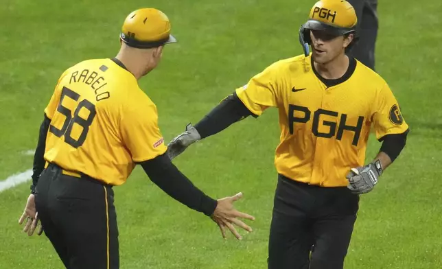 Pittsburgh Pirates' Adam Frazier, right, is greeted by third base coach Mike Rabelo (58) after hitting a solo home run off pitcher Wandy Peralta during the fifth inning of a baseball game in Pittsburgh, Friday, May 2, 2025. (AP Photo/Gene J. Puskar)