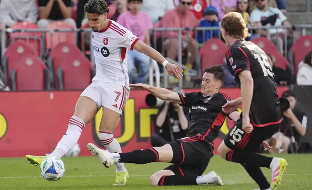 D.C. United defender David Schnegg, center, tries to stop a pass by Toronto FC forward Theo Corbeanu (7) during the second half of an MLS soccer game in Toronto, Saturday, May 10, 2025. (Frank Gunn/The Canadian Press via AP)