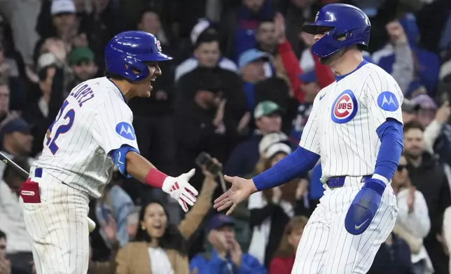 Chicago Cubs' Nico Hoerner, right, celebrates with Nicky Lopez, left, after scoring on a two-run single by Dansby Swanson during the fourth inning of a baseball game against the San Francisco Giants. in Chicago, Monday, May 5, 2025. (AP Photo/Nam Y. Huh)